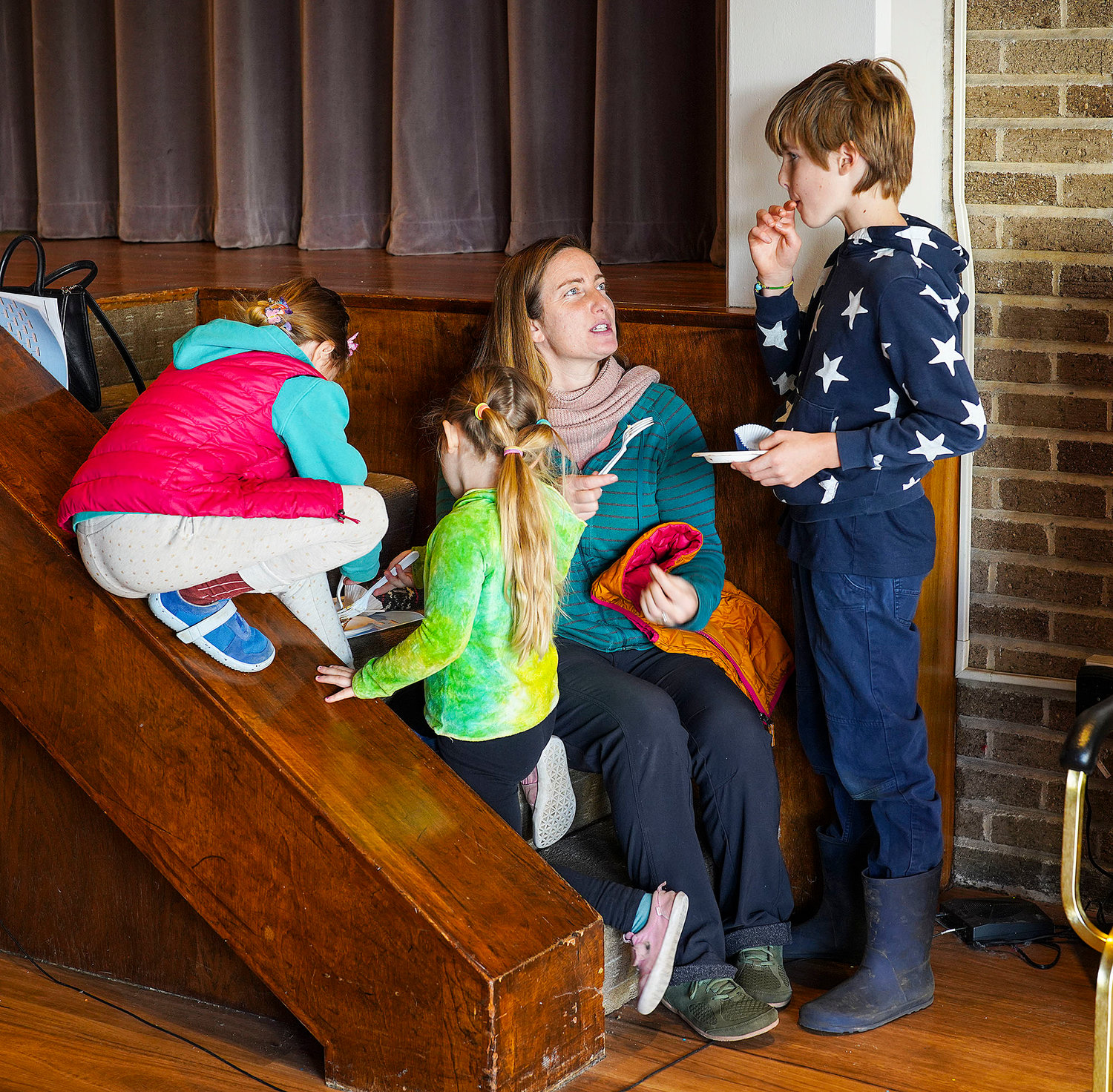 Jennie Theriaque,  and her children, l to r, Leah, 8,  Talia, 5, and Caleb, 11, taste several of the bake goods on the steps to the stage at the temple.