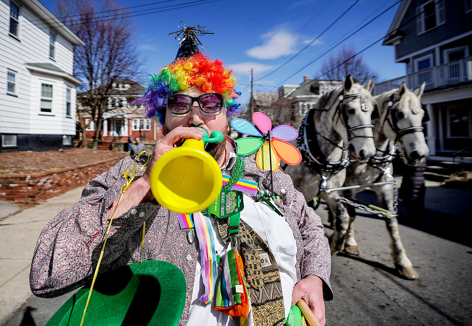 Naftali Karp, of Providence, walks down Morris Avenue in front of horses pulling a wagon on the parade route.