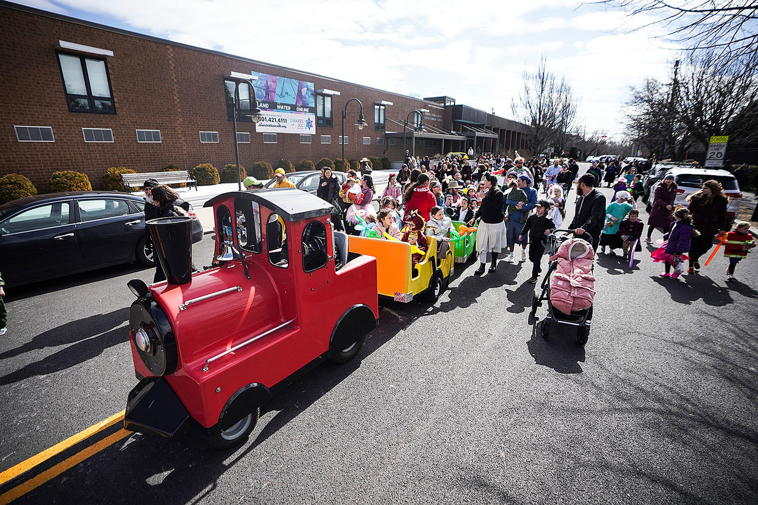 Kids get a ride as the parade ends in front of the Dwares Jewish Community Center.