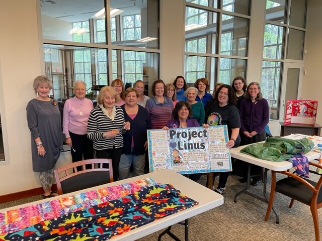 Project Linus Mitzvah Day participants display some of their quilts.