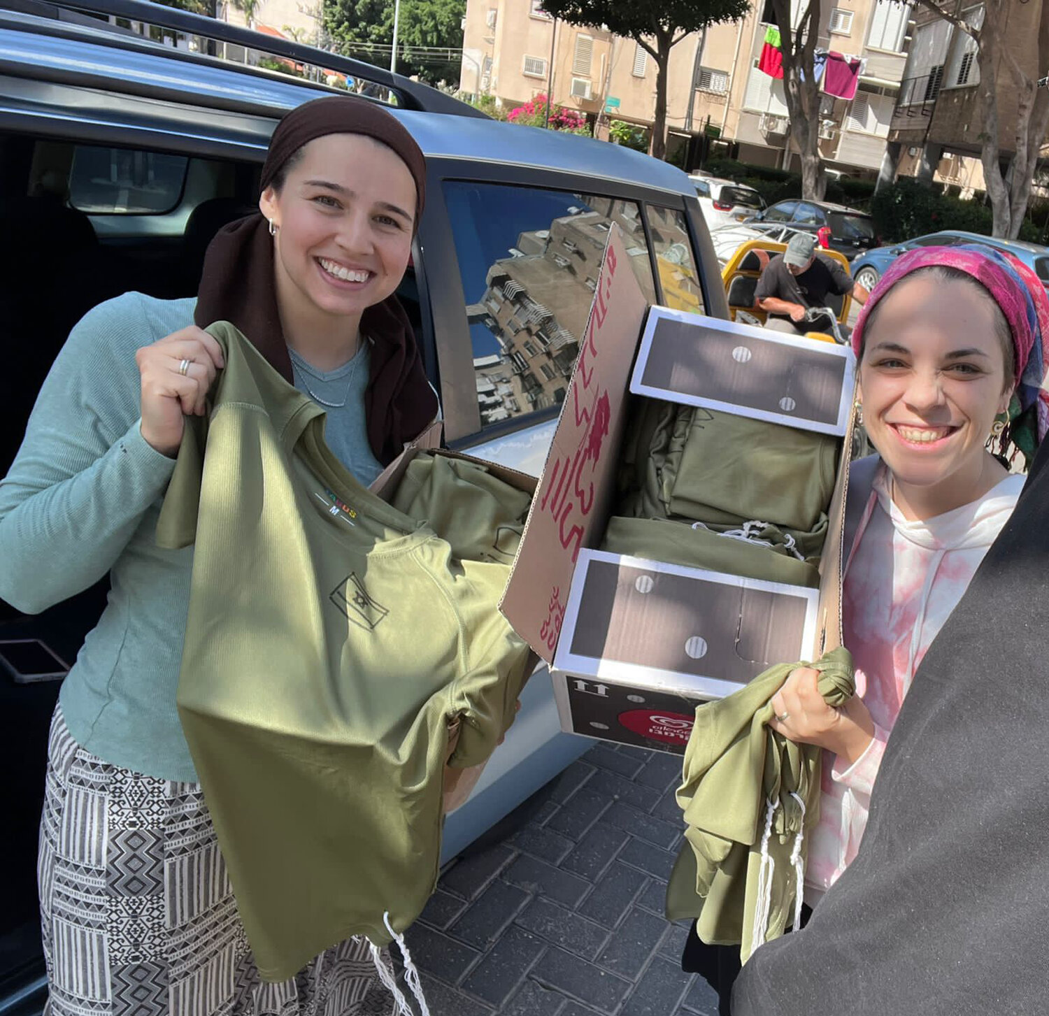 Elanah Oberg and a friend deliver a box of tzitzi for IDF soldiers.
