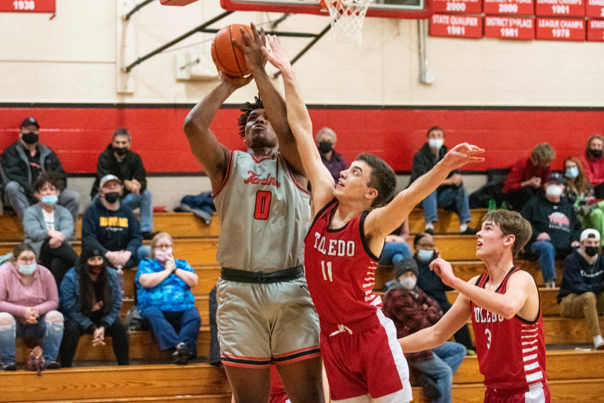 Toledo's Carson Gould (11) defends in the paint against Tenino's Takari Hickle (0) on Dec. 22.