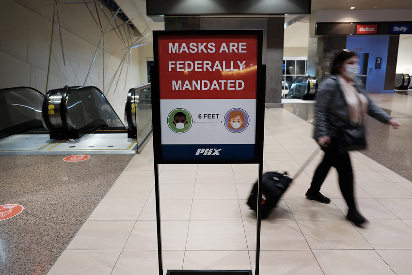People walk through Sky Harbor International Airport in Phoenix where new COVID-19 cases are down but health experts warn cases may rise with the introduction of the omicron strain on Dec. 18, 2021, in Phoenix, Arizona. (Spencer Platt/Getty Images/TNS)