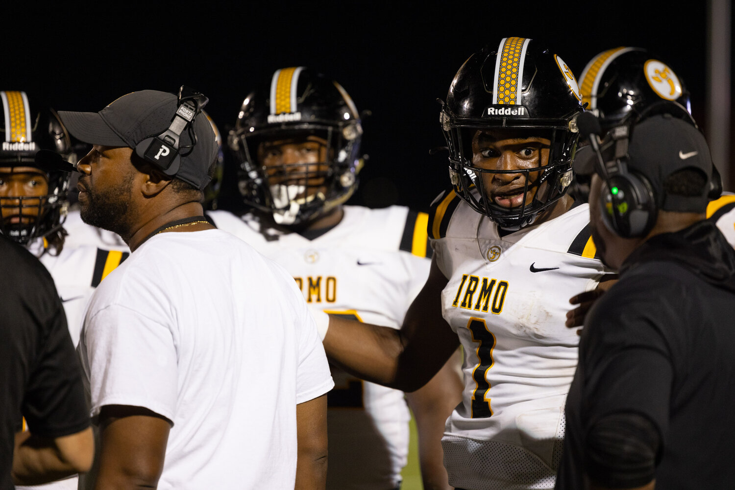 Irmo quarterback A.J. Brand speaks with a coach on the sidelines during the second quarter.