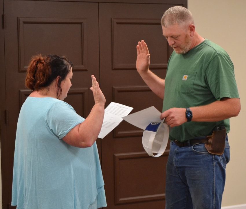 Marshall County Clerk Daphne Girts delivers the oath of office to James Hopkins, who was appointed by the commission to the vacant 8th District seat on Monday night.