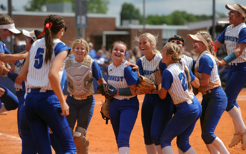 The Lady Rocket dugout empties and swarms pitcher Taylor Moreland after the final out is recorded, securing Forrest&rsquo;s spot in the upcoming Class 2-A state tournament.