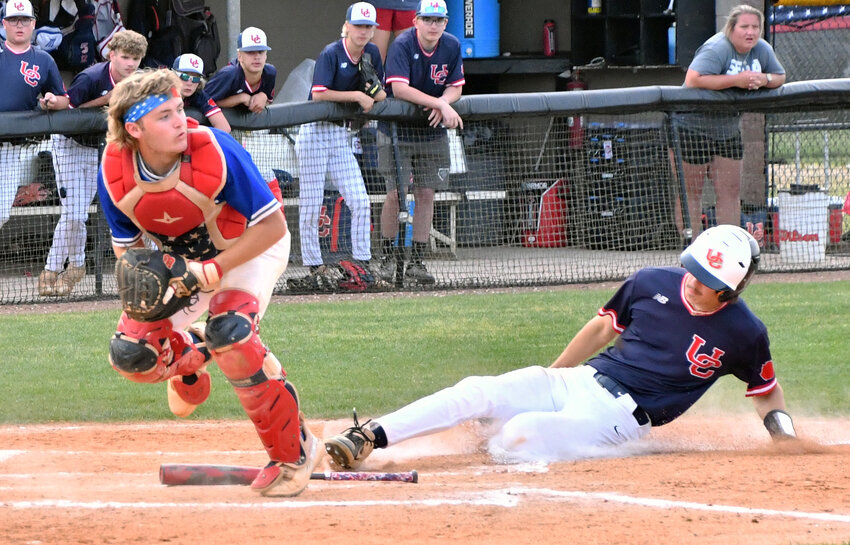 Catcher Tyler Baxter of the Rockets looks over the situation after receiving a throw from Luke Allen for a force play at the plate.