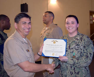 Capt. Matthew Rick congratulates Operations Specialist 2nd Class Audrey McCulloch (right) with Navy and Marine Corps Achievement Medal.
