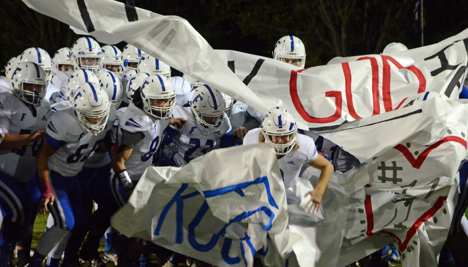 Forrest senior Hunter Pendley (center) busts through the banner first, leading the Rockets out on to the field for the Region 5-AA title tilt at Bobby M. Sharp Stadium in Hohenwald Friday night.