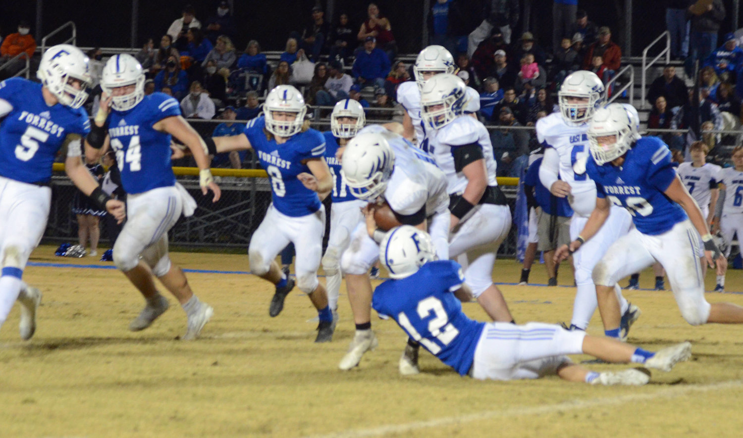 Senior Cole Perryman (12) comes up for the tackle on East Hickman running back Cooper Harris.