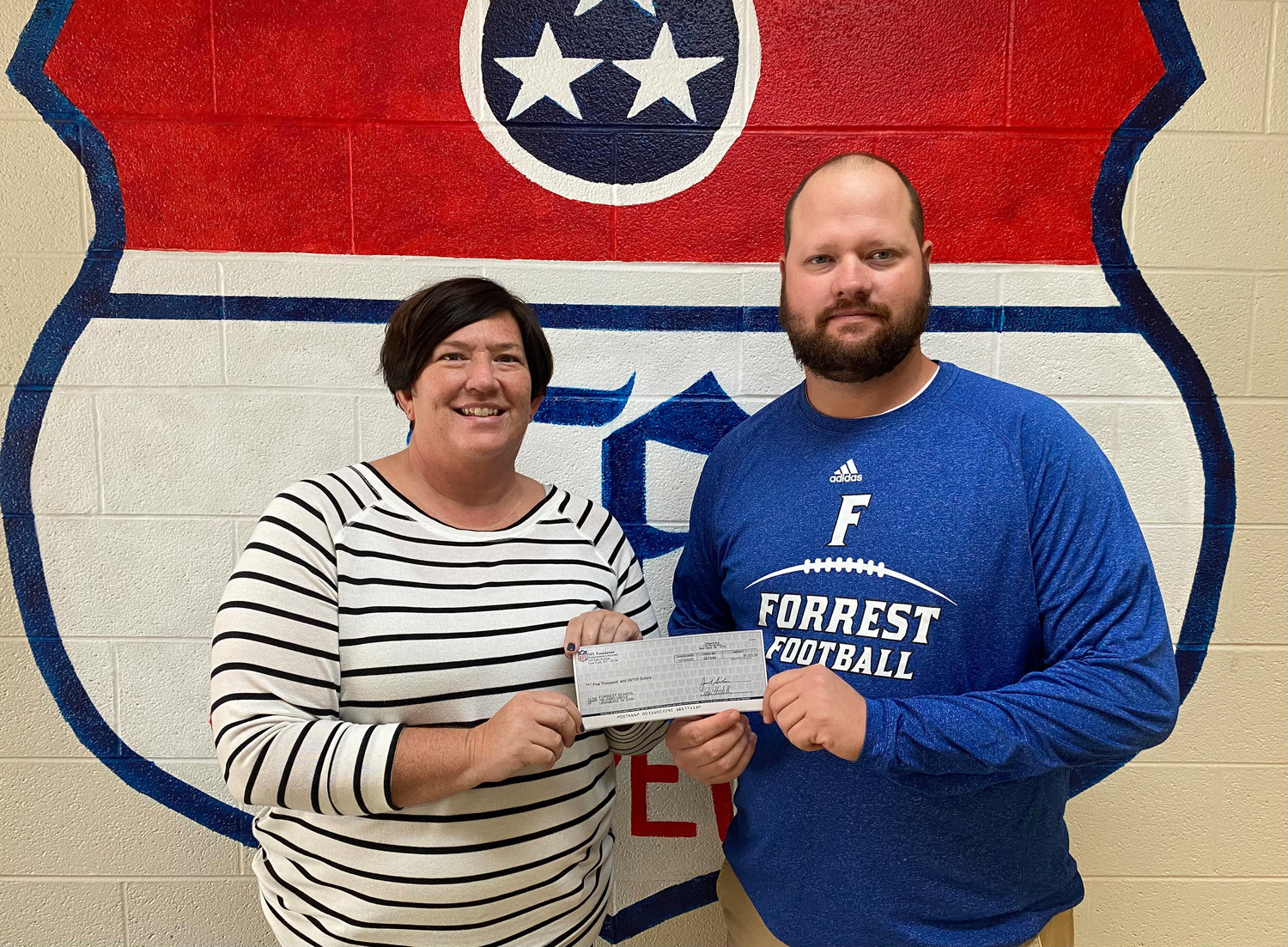 Forrest principal Angie Phifer and Rockets' football coach Eli Stephenson accept the check from the NFL Foundation.
"Forrest School and Forrest Football recently received a huge honor," Phifer said. "We were selected to receive one of the 2019 NFL Foundation Super Bowl High School Honor Roll Grants!!"
"HUGE shout out to Mr. Dont’a Hightower, linebacker for the New England Patriots, for nominating us!! We are very honored to be nominated and so appreciative of his support!! We would like to say a big THANK YOU to Dont’a and the NFL Foundation from Forrest School and Forrest Football!!"