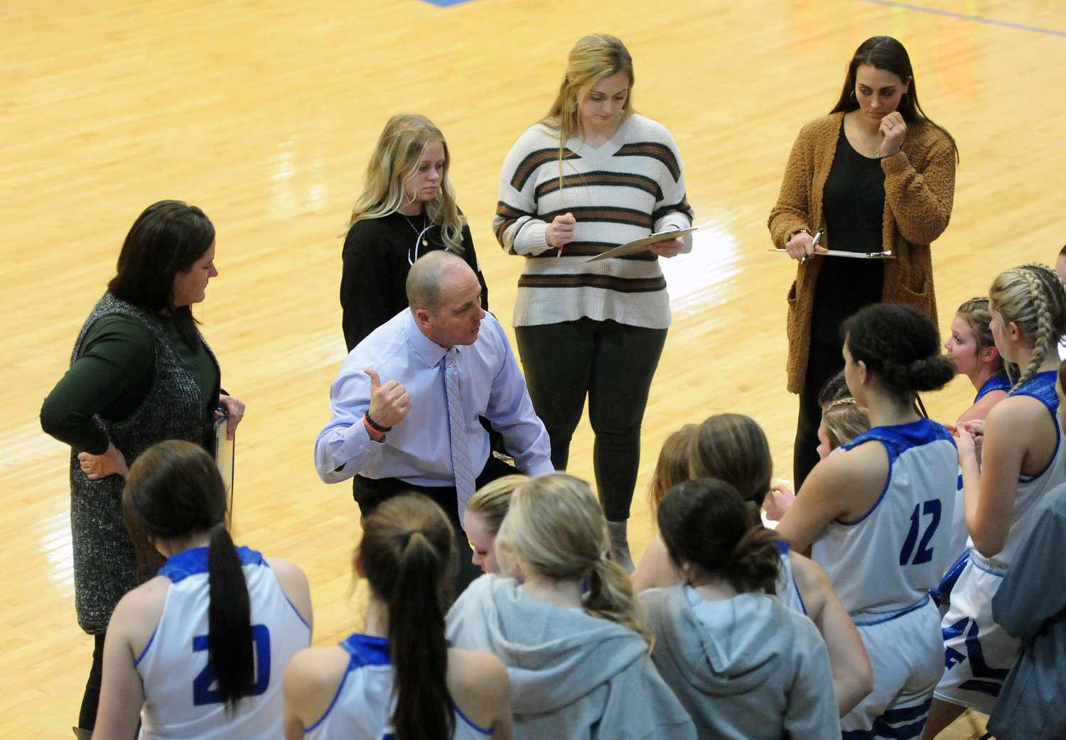Lady Rocket coach Hal Murrell huddles up with his team during a timeout against Grundy County.