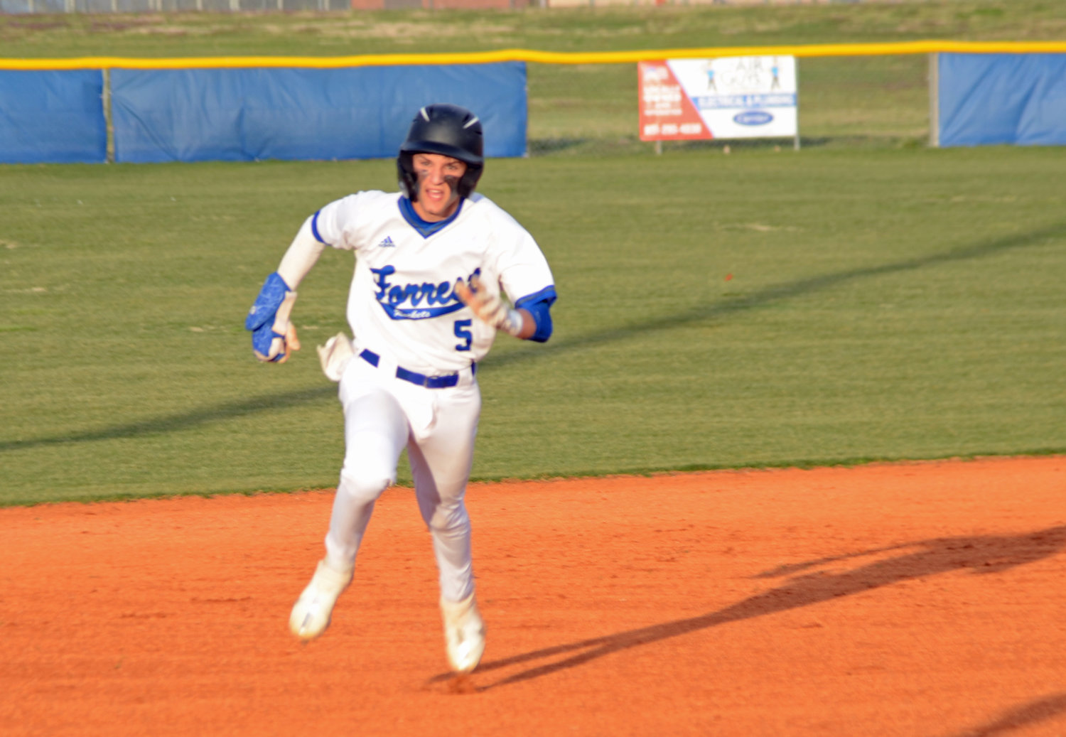 Forrest’s Camden Vaughn rounds second base and heads for third in the top of the first inning for the Rockets.