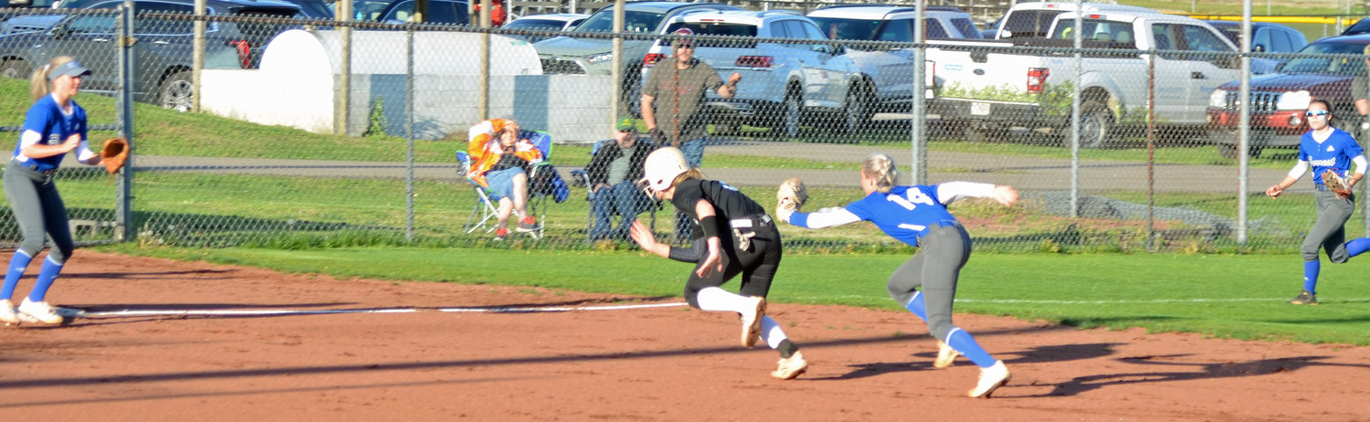 Briley Burnham (14) chases down Cornersville’s Alicia Polk (3) on a rundown play in the bottom of the first inning.