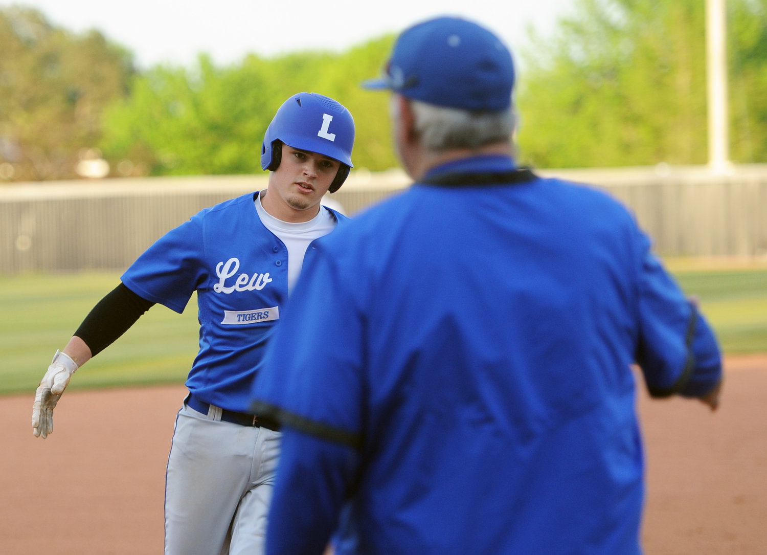 Senior Bryson Hammons catches five from coach Mike "Monk" Reese after mashing a solo home run on Thursday at Cascade.