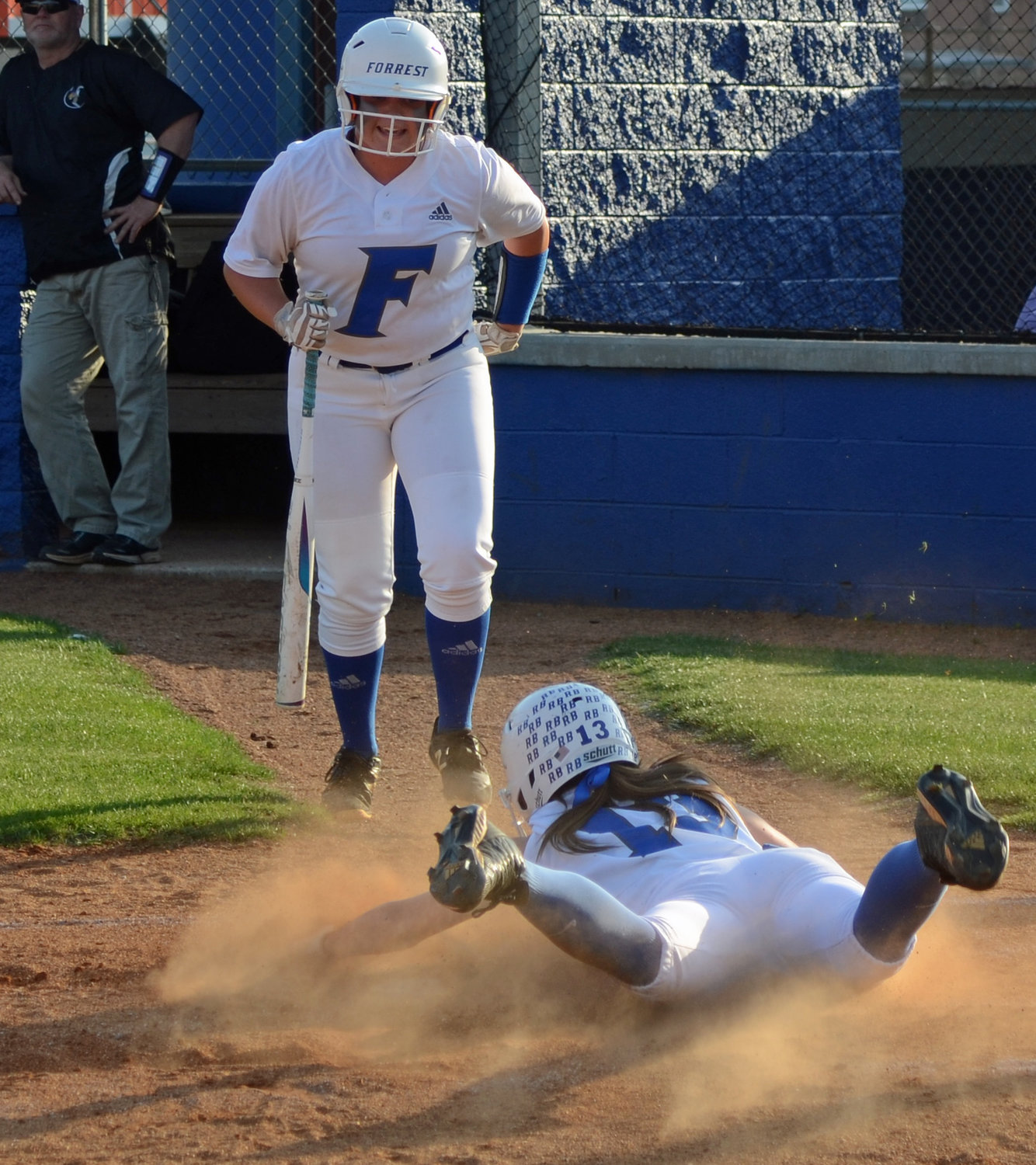 Addison Bunty slides head first to home after rounding the bases in the first inning.