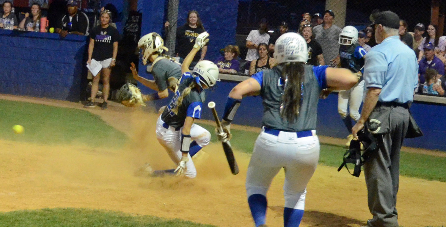 Maggie Daughrity scores the winning run for the Lady Rockets, who came back to beat Community 10-9 in Thursday night’s District 7-AA Tournament title game at the Field of Dreams in Chapel Hill.