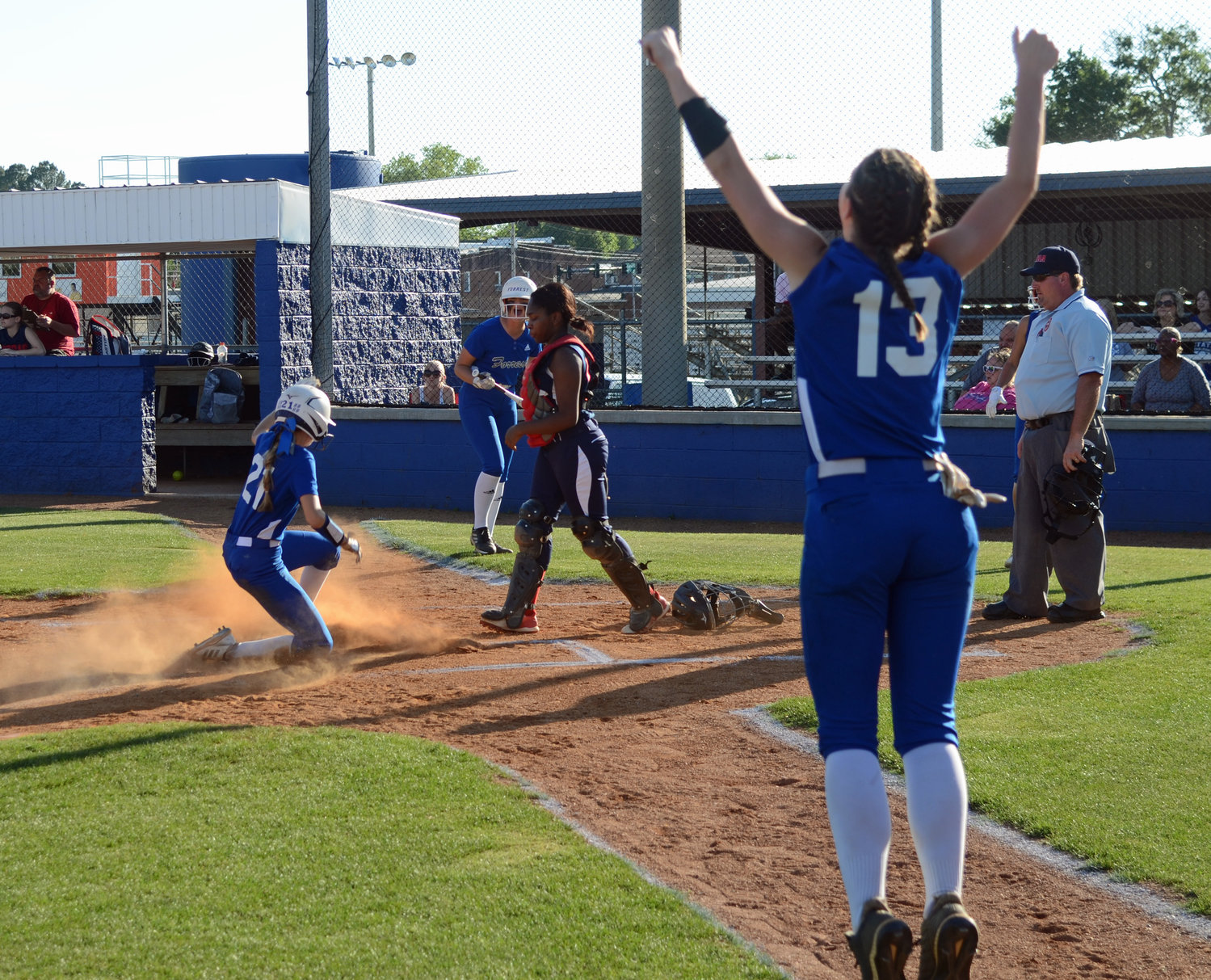 Addison Bunty (13) cheers as Maggie Daughrity slides home with an inside the park home run. 