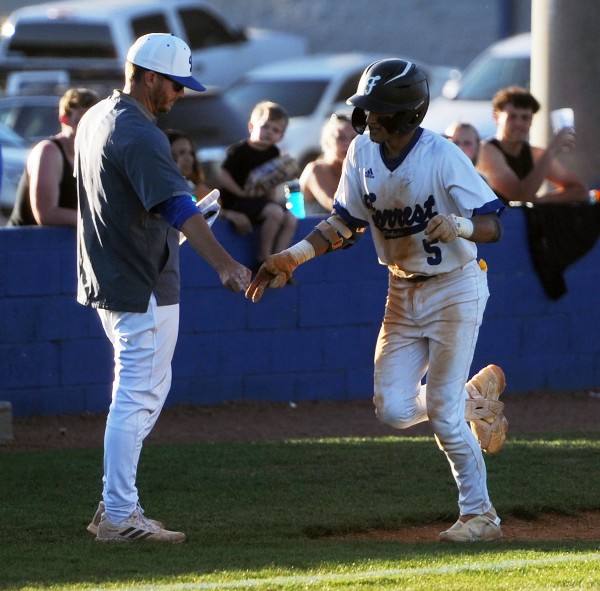 Rocket senior Camden Vaughn catches a fist bump from coach Andy Burkett after mashing a grand slam in the third inning against Stratford on Monday.