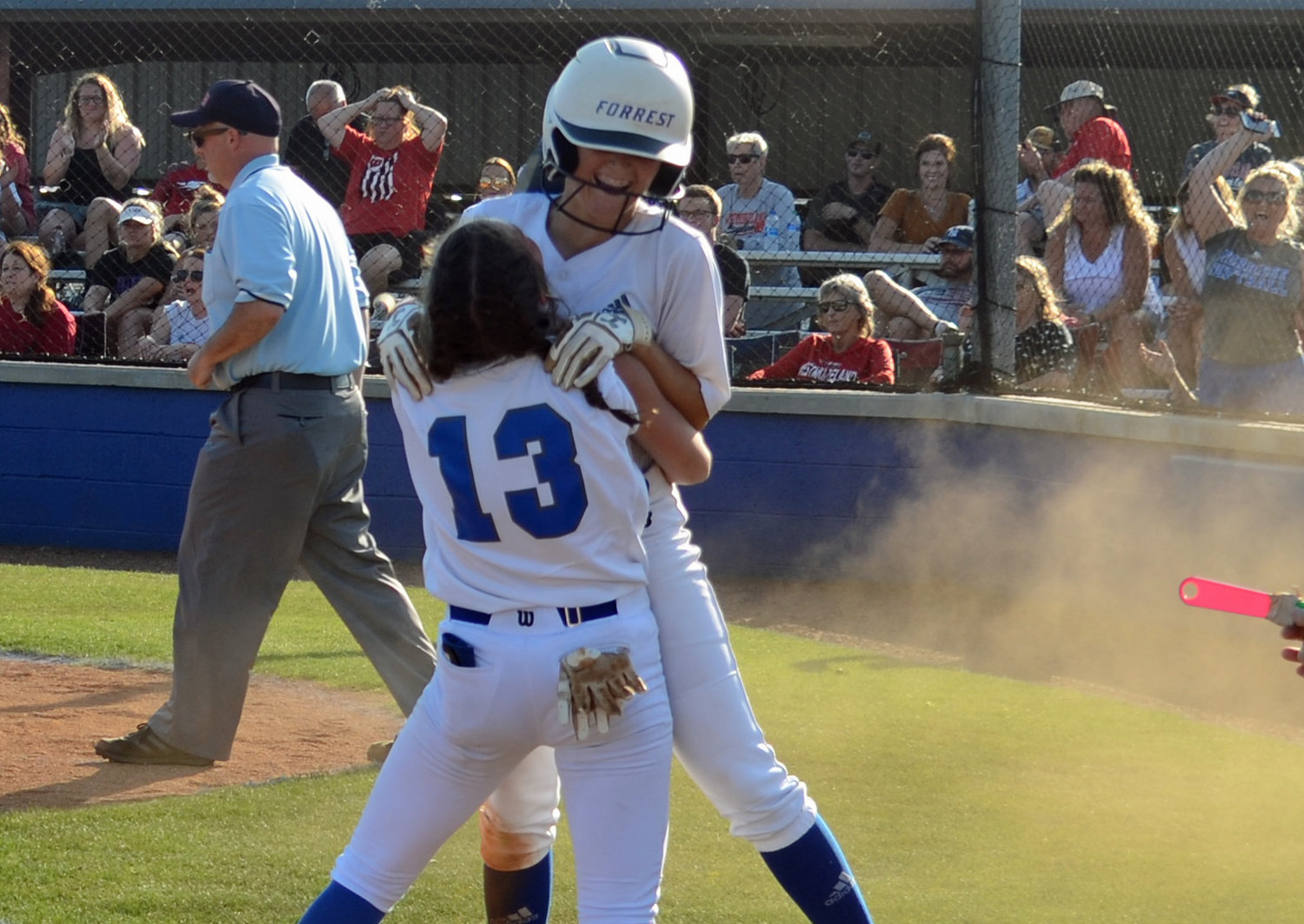 Addi Bunty lifts Maggie Daughrity off the ground after Daughrity’s inside the park homerun in the third inning.