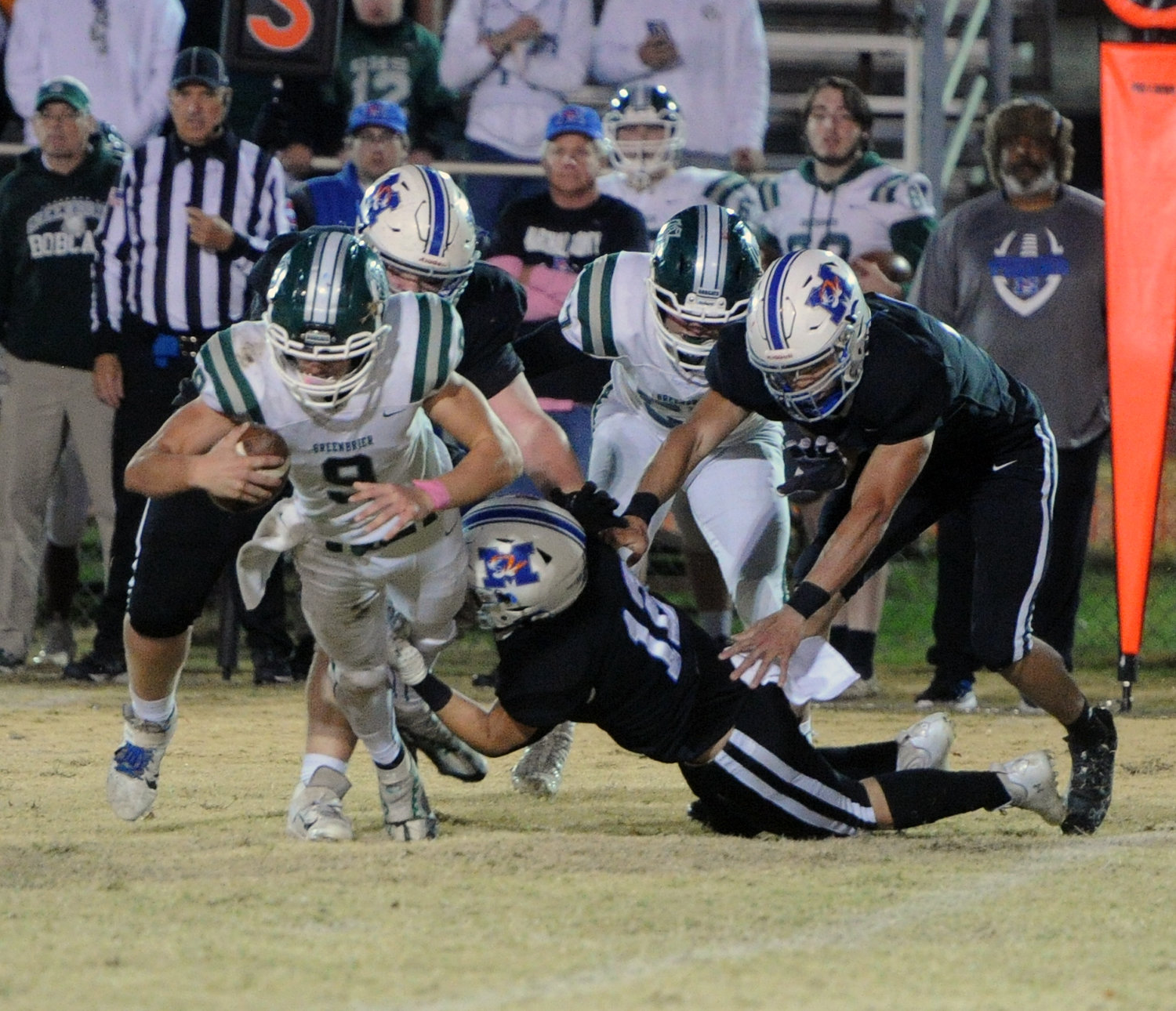 A host of Tiger defenders bring down Bobcat quarterback Nolan Carson for a loss in the backfield.