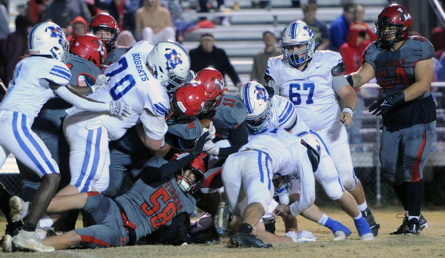 A host of Marshall County defenders jump on the pile to bring down talented Lexington quarterback Isiah McClaine.