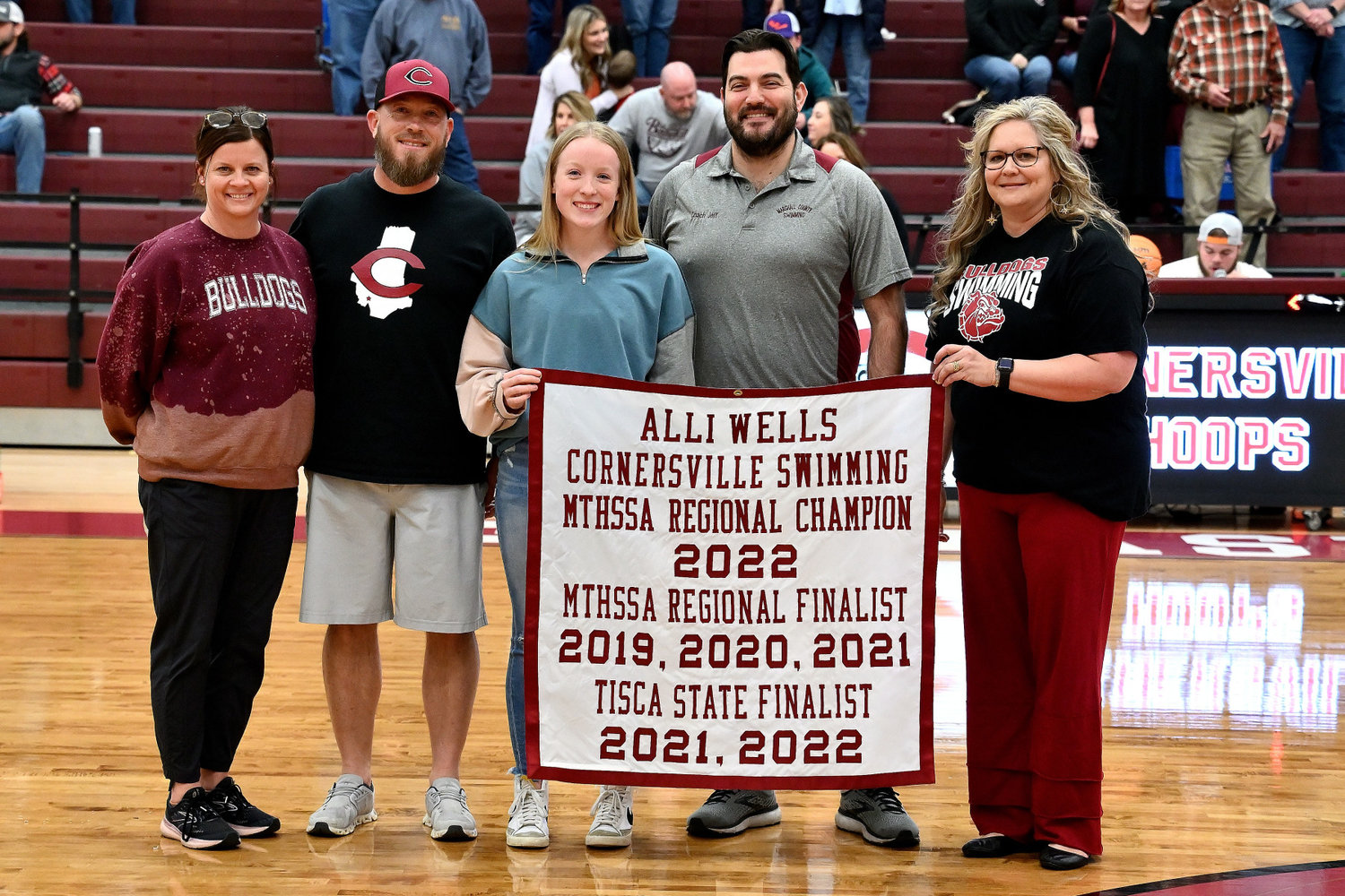 Wells, along with her family, is presented with a banner listing out her numerous accomplishments that will hang in the school’s gym.