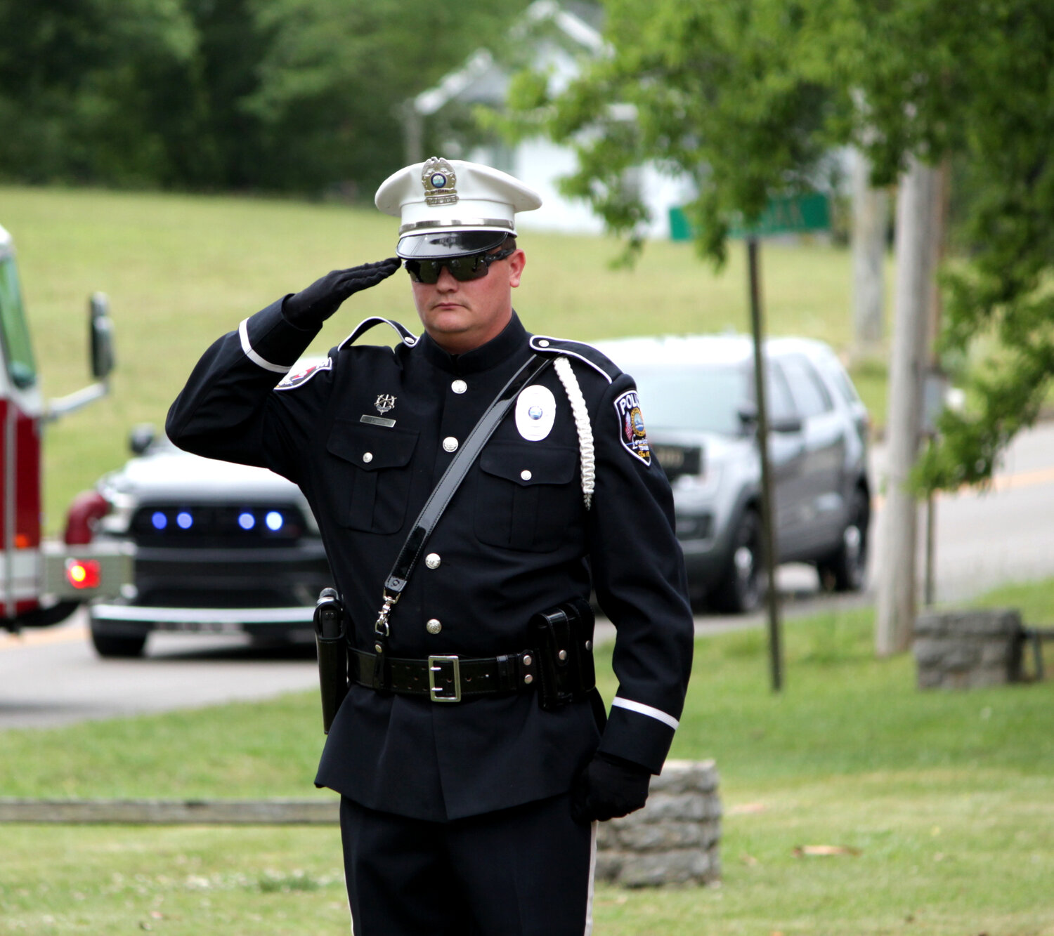 Officer Turner stands at salute as attendees take part in the Pledge of Allegiance after the flag was flown up the pole at the Abner Houston Memorial Cabin.