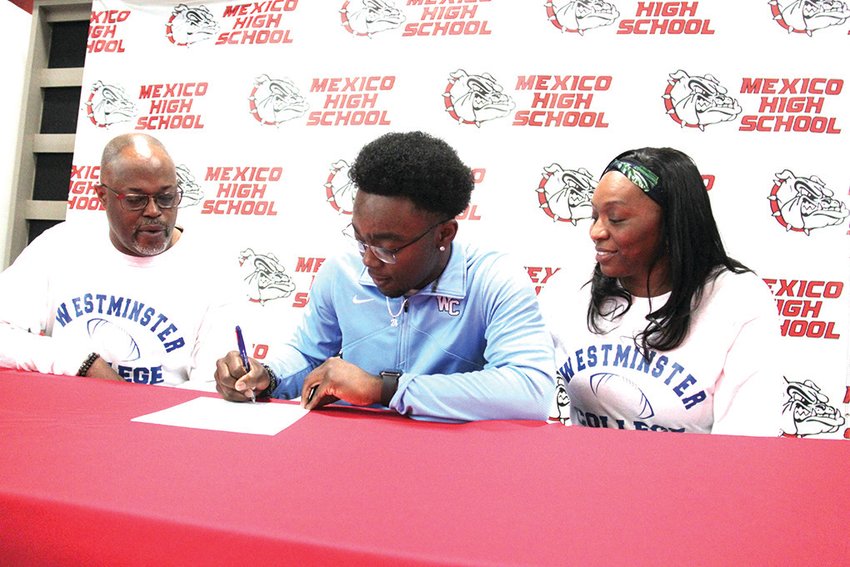 Bulldogs running back Dante Billups is flanked by his father and mother, Arthur and Alexandria Bradshaw, as he signs a national letter of intent on Thursday to play football for Westminster College. [Dave Faries]