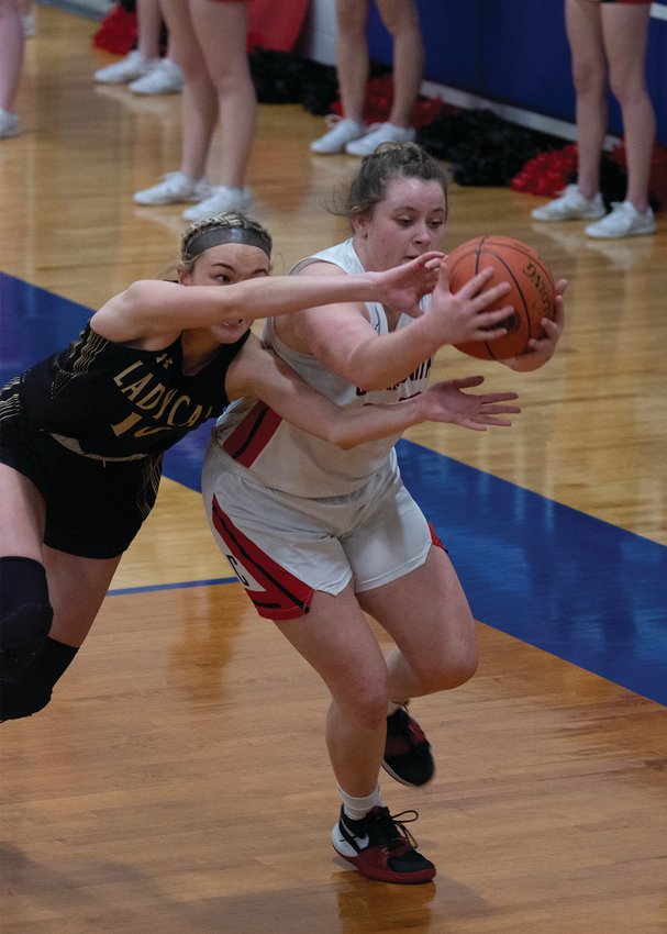 Community R-6&rsquo;s Alexis Welch beats Cairo's Macie Harman to a loose ball during the Class 2, District 5 championship game Friday night. The Lady Trojans fell 44-37 to the Lady Bearcats. They end the season with a 23-4 record. [Leslie A. Meyer Photography]