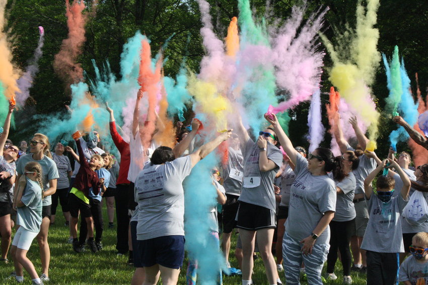 Participants in the second Uplift Mid-Mo Color Run throw different colors of powder up in the air Saturday before the start of the race at Teal Lake Shelter in Mexico. The proceeds that amounted to about $4,500 this year will go toward supporting local residents in need. [Jeremy Jacob Photo]