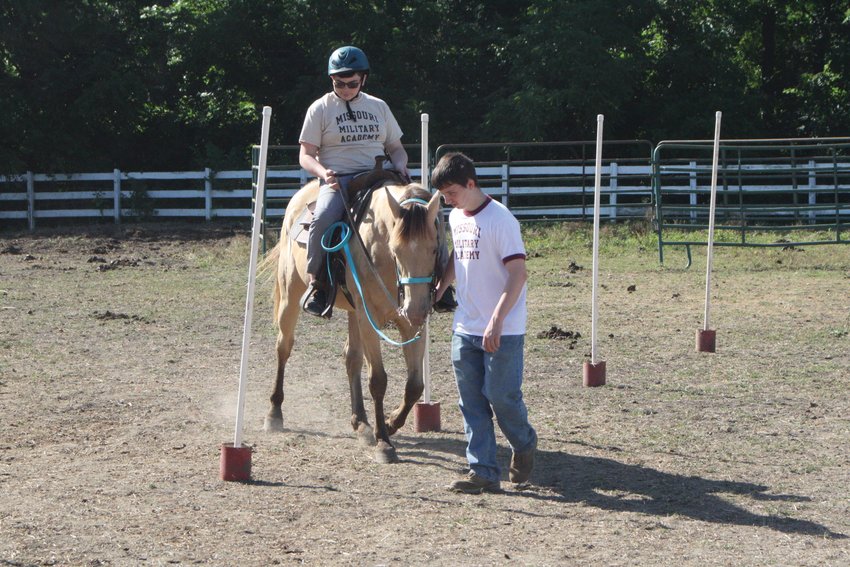 Campers at the Missouri Military Academy equestrian camp maneuver around poles while on their horses on June 29. Before hitting the trail, campers saddled their horses and did some work to test their control.