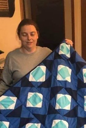 Christina Boyd proudly holds a quilt that was sold by her and sister Amanda Bennett as the two siblings have opened up an online craft store. (Submitted photo)