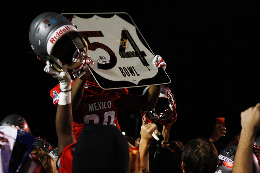 Mexico senior running back Anthony Shivers is hoisted on the shoulders of his teammates Friday after the Bulldogs' 54-7 victory at home against Fulton in the 54 Bowl. Shivers ran for 197 yards and four touchdowns on 10 carries so he had the privilege of holding the trophy, a decommissoned road sign, awarded to the winning team every year.
