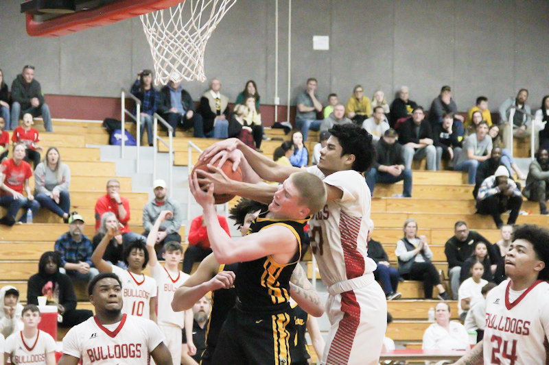 Mexico senior Dante Kelley fights Fulton's Walker Gohring for a rebound on Tuesday during the Bulldogs' 56-45 win at home against their conference rival. Kelley made a difference on the defensive end.
