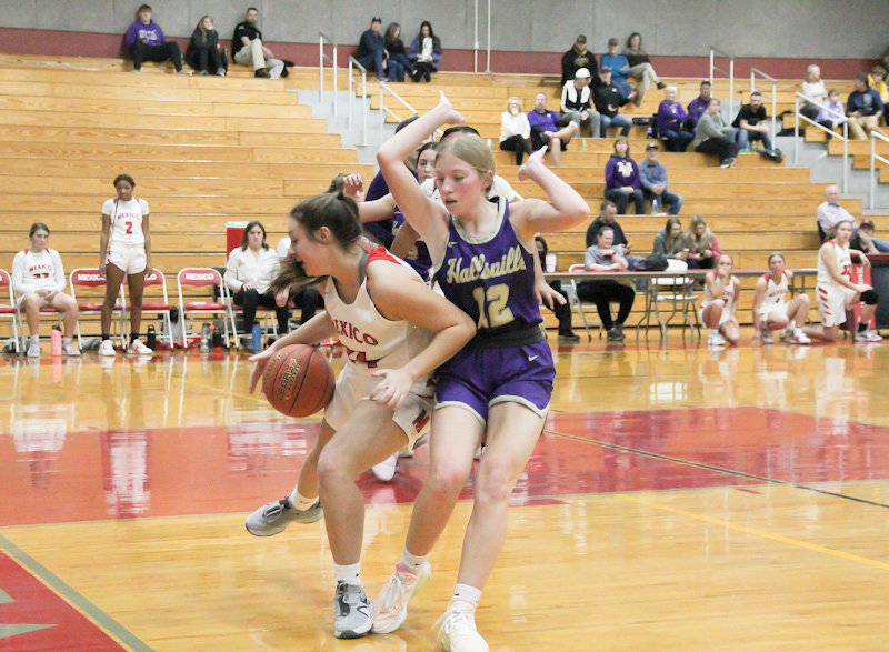 Mexico junior Kylie Burnett evades the Hallsville defense on Wednesday night at home. The Lady Bulldogs lost 64-30 after a lopsided third quarter.