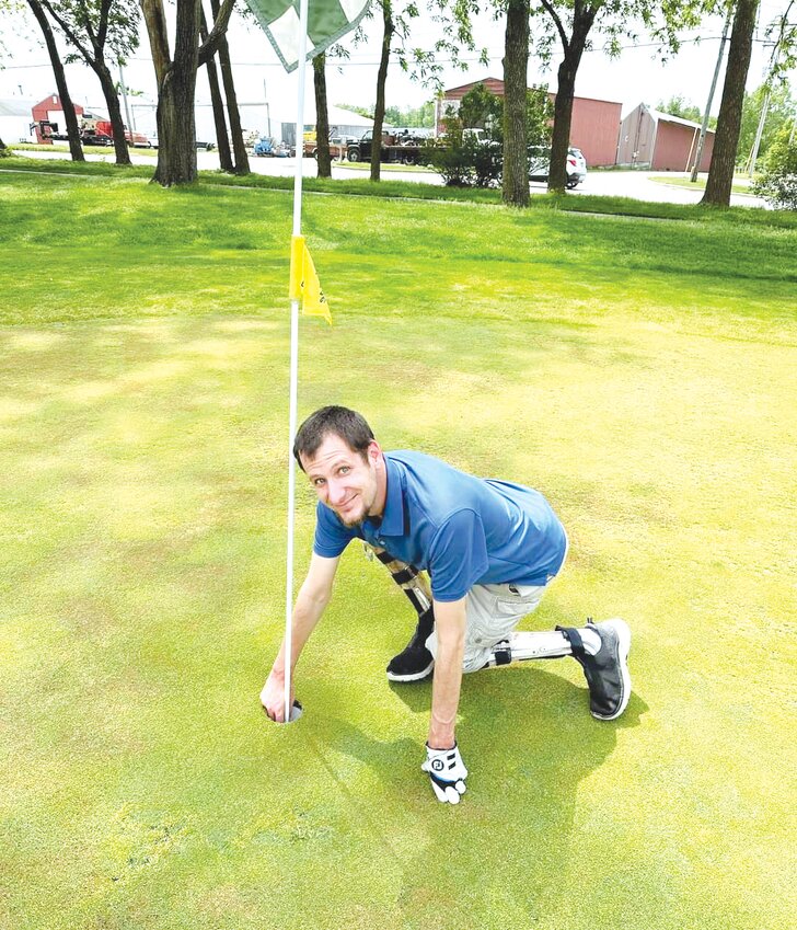 Mexico man Jason Moore pulls his ball out of a hole on May 14 at The Oaks in Mexico after sinking a hole in one. Moore has spina bifuda and scoliosis but achieved the rare feat despite his condition.