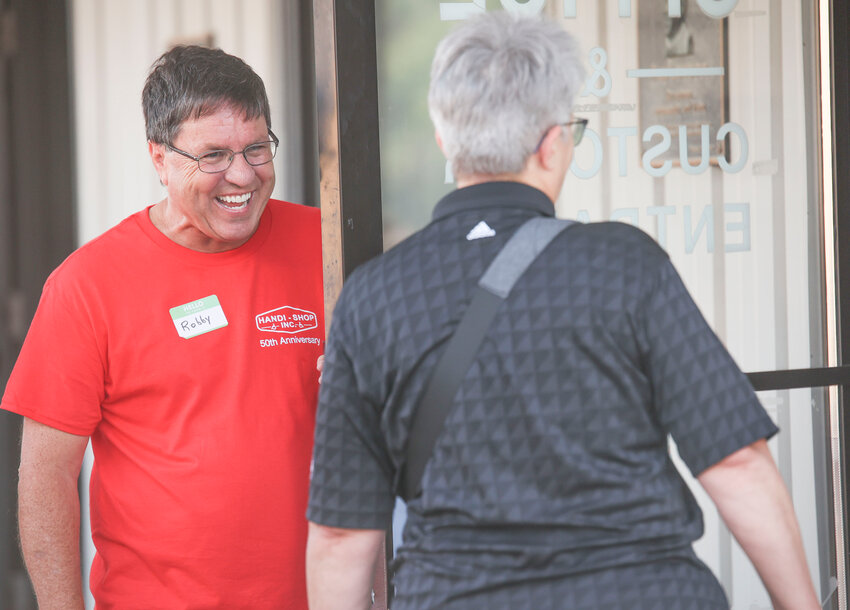 Handi Shop Board Member Robby Miller greeted people at the Shop&rsquo;s 50th anniversary celebration on Thursday, Sept. 21.