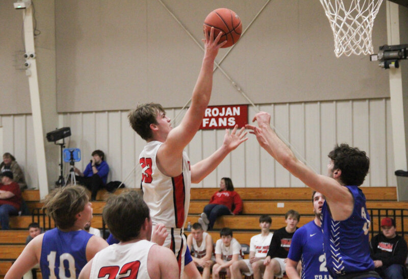Community R-6 senior Mason Carroll floats a shot over a New Franklin defender on Thursday at home. The Trojans lost in lopsided fashion to their state-ranked conference foe but celebrated Carroll's accomplishment of scoring 1,000 points in his career.