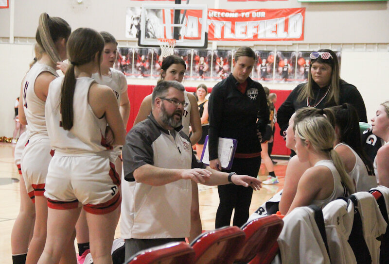 Community R-6 head coach Bob Curtis discusses strategy with his team during a timeout in a game last season.