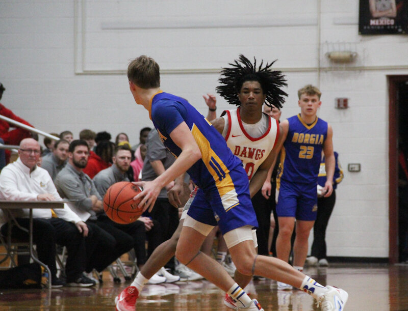 Mexico junior PJ Perkins guards St. Francis Borgia senior Adam Rickman closely on Tuesday during a Class 4 state sectional game at Gary Filbert Court in Mexico. The Bulldogs won 62-56 to advance to Saturday's quarterfinal game at Vashon.