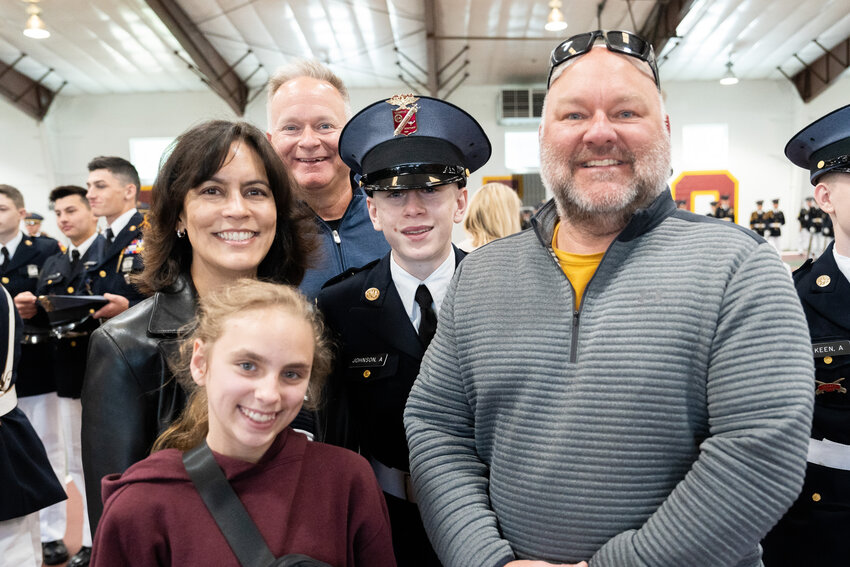 Cadet Alex Johnson, an eighth grader from Zionsville, Ind., stands with his family after receiving his MMA hat brass at the Passing Through Ceremony during Spring Family Weekend.