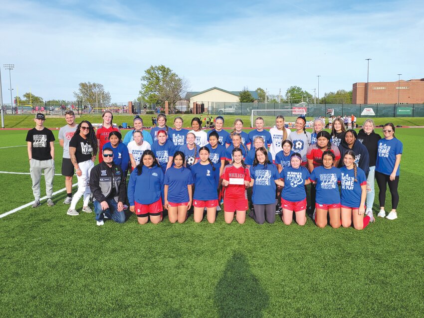 The Mexico Lady Bulldogs gather with their late teammate Emma Azdell&rsquo;s family after giving them a donation check to the Emma Azdell Scholarship Fund. The gesture was before Mexico&rsquo;s April 22 home game against Kirksville at Chris Hotop Field in Mexico.