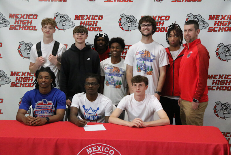 Mexico senior DJ Long gathers with his Mexico teammates and head coach Darren Pappas on Friday in Mexico during his signing ceremony to play basketball for Kansas City Kansas Community College. Long was there with his family and friends as he became the third Mexico star in three years to go to the next level.