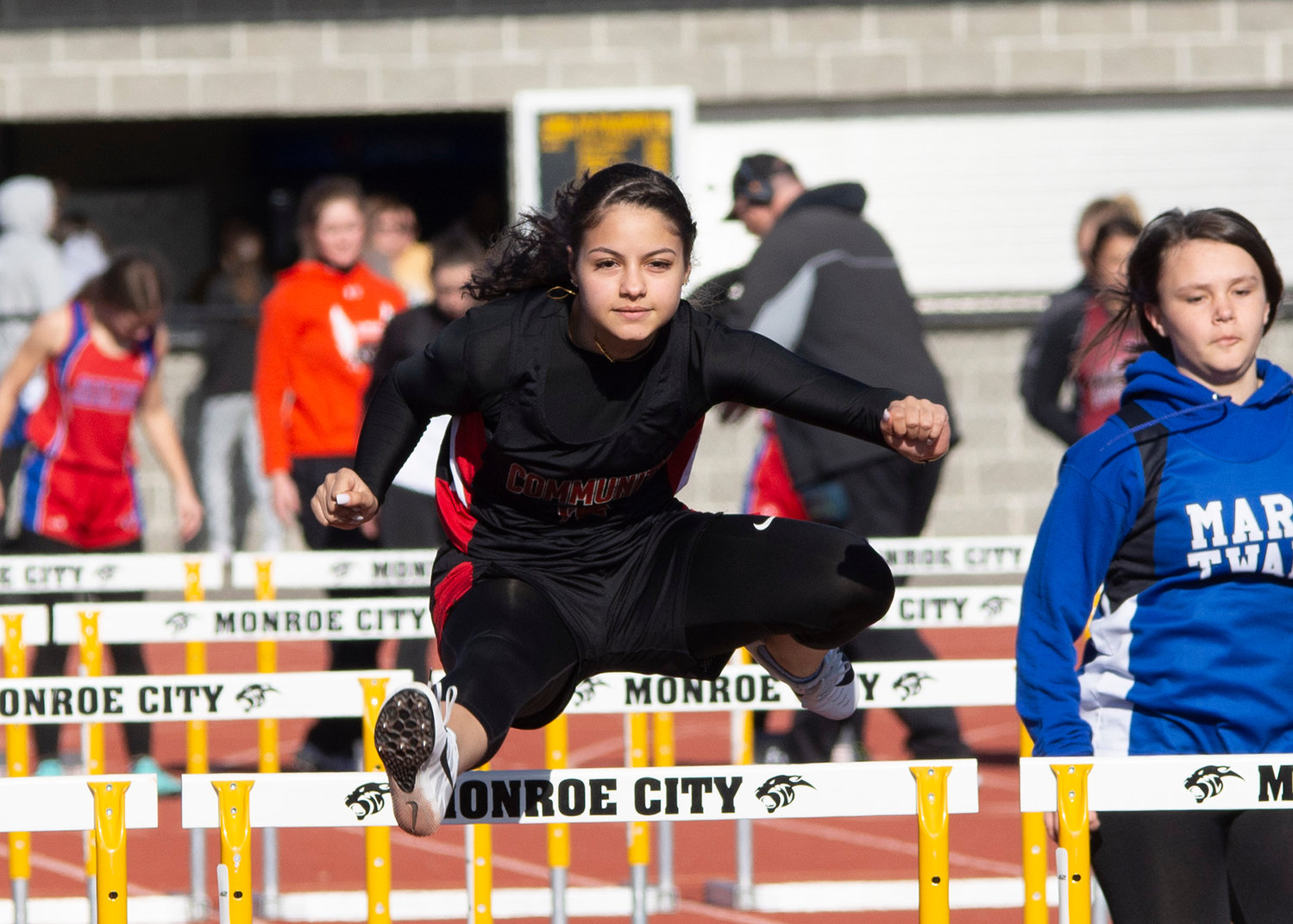 Trojans' Sophomore Victoria DiSalvo competes in the 100 meter hurdles on Thursday in the Monroe City Invitational. She finished in the points, crossing the line eighth. [Leslie A. Meyer Photography]