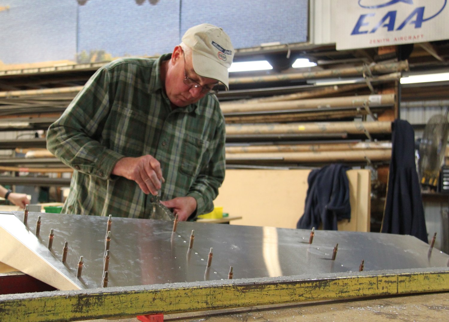 Chris Carstens inspects his first go at working with sheet metal during a recent workshop. [Dave Faries]