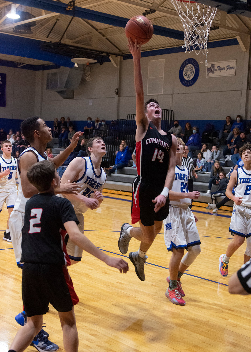Sophomore forward Tucker Robnett goes up for the basket to score for the Trojans. [Leslie A Meyer Photography]
