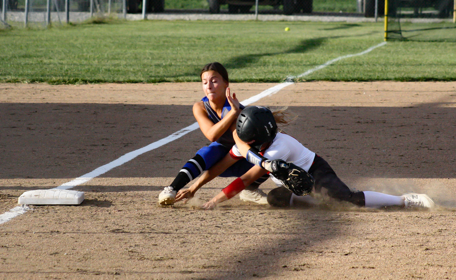 Community R-6 senior shortstop Sarah Angel slides into New Franklin third baseman Addy Salmon in the Lady Trojans' 7-1 loss Monday in Laddonia. Angel reached base in all three of her plate appearances but was thrown out trying to steal third base.