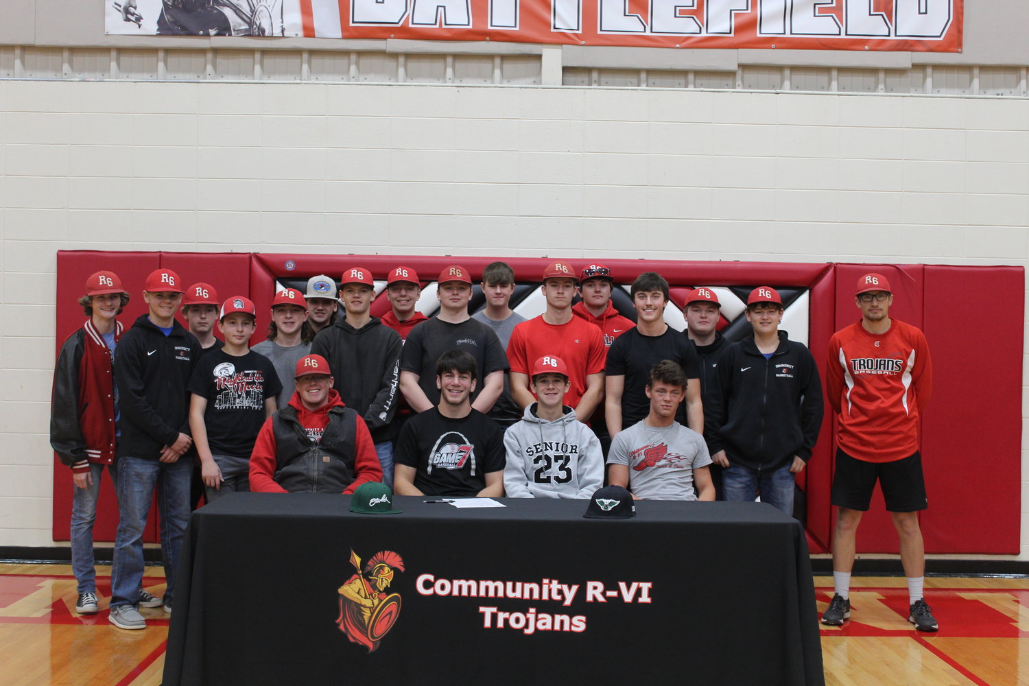 Community R-6 senior pitcher Gavin Allen is joined by his teammates and head coach Joel Krato at the table he signed his letter of intent Thursday to play baseball at William Woods University in Fulton in a ceremony at Community R-6 High School in Laddonia.