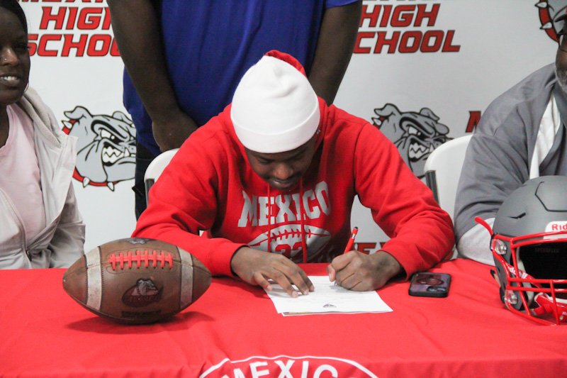 Mexico senior Tre'Von Gardner signs his letter of intent on Monday to play sprint football at Quincy University.